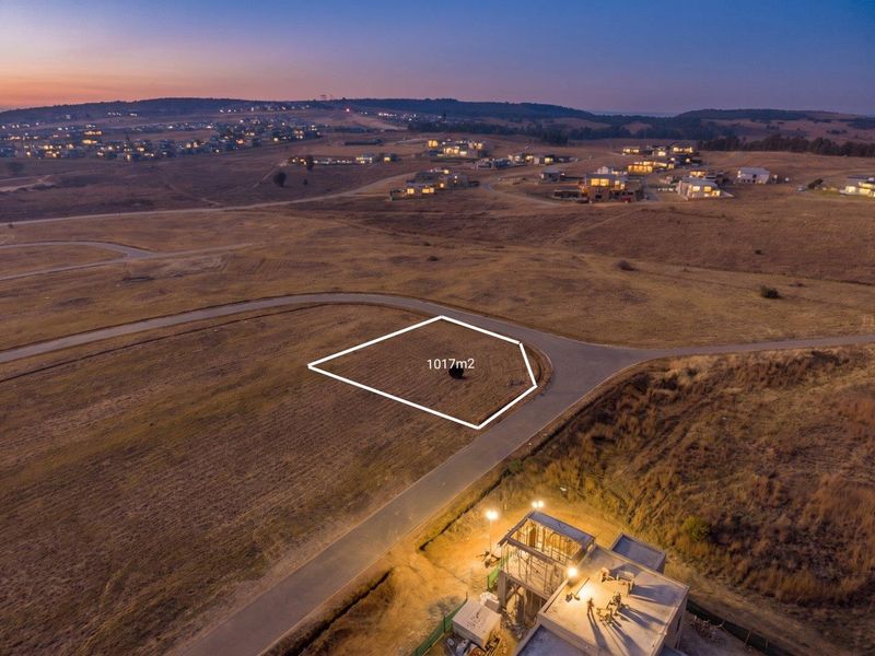 An aerial view of a 1017m2 vacant residential plot situated in a developed estate with paved road access.