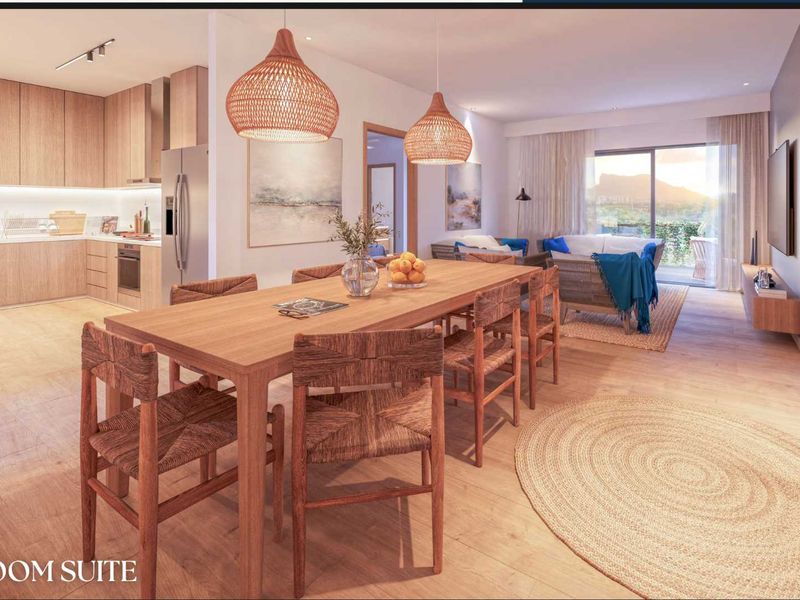 Modern open-plan living area featuring a sleek kitchen with integrated cabinetry, dining space, and seamless flow to a balcony with scenic views.