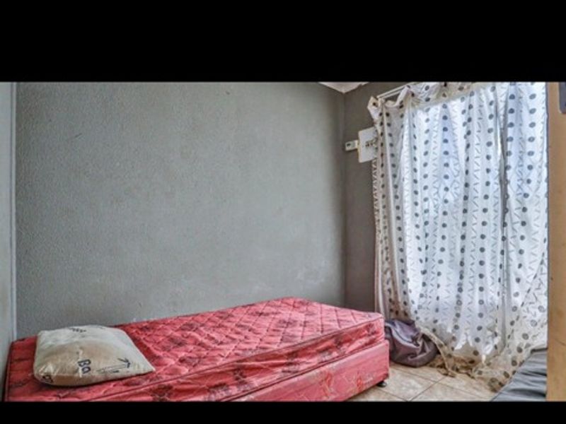 A bedroom featuring tiled flooring and unfinished wall surfaces, offering a blank canvas for potential renovation and interior design updates.