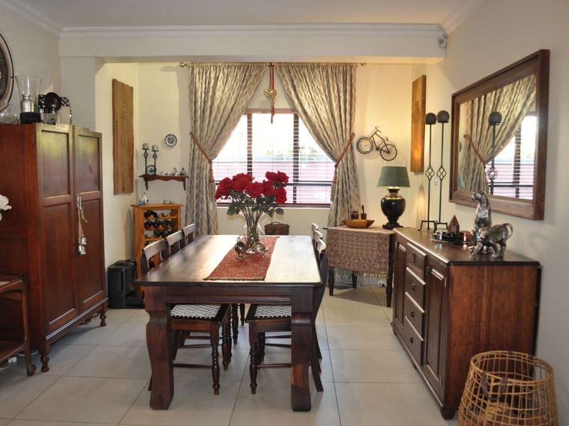 A dining room featuring tiled flooring and crown molding, providing a functional space for family meals and entertaining.