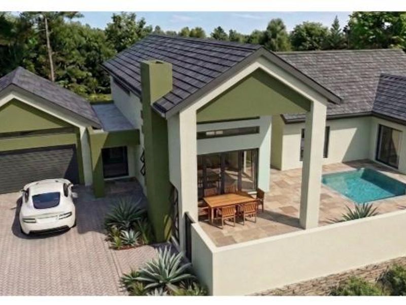 Aerial view of a modern residential property featuring a tiled roof, swimming pool, covered patio, and paved driveway within a landscaped setting.
