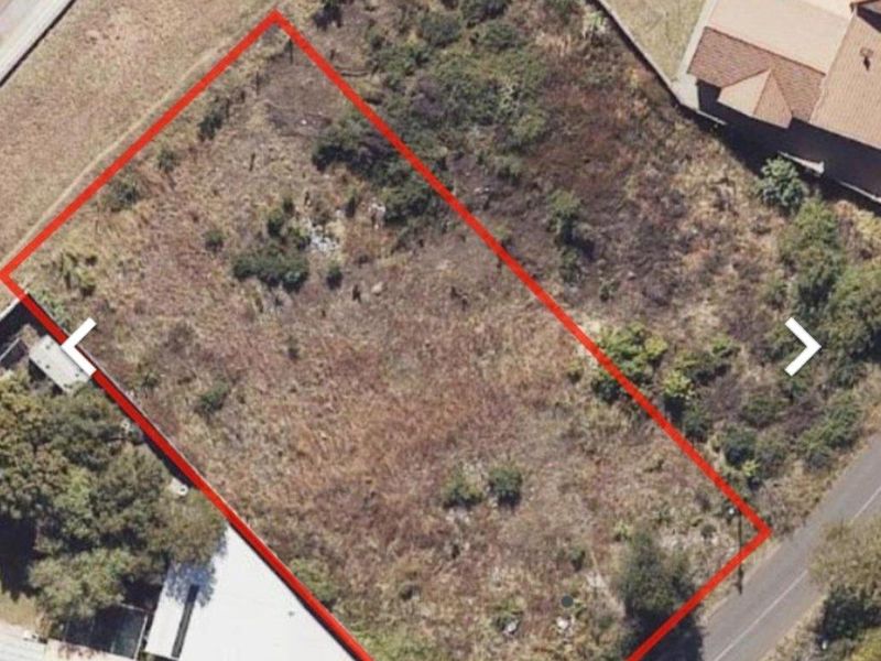 An aerial view of a vacant residential plot of land, showing the property boundaries and surrounding neighborhood context.