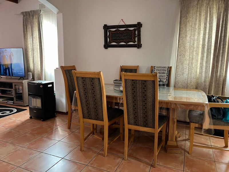 A dining room area featuring tiled flooring and an architectural archway, providing a functional space for family meals.