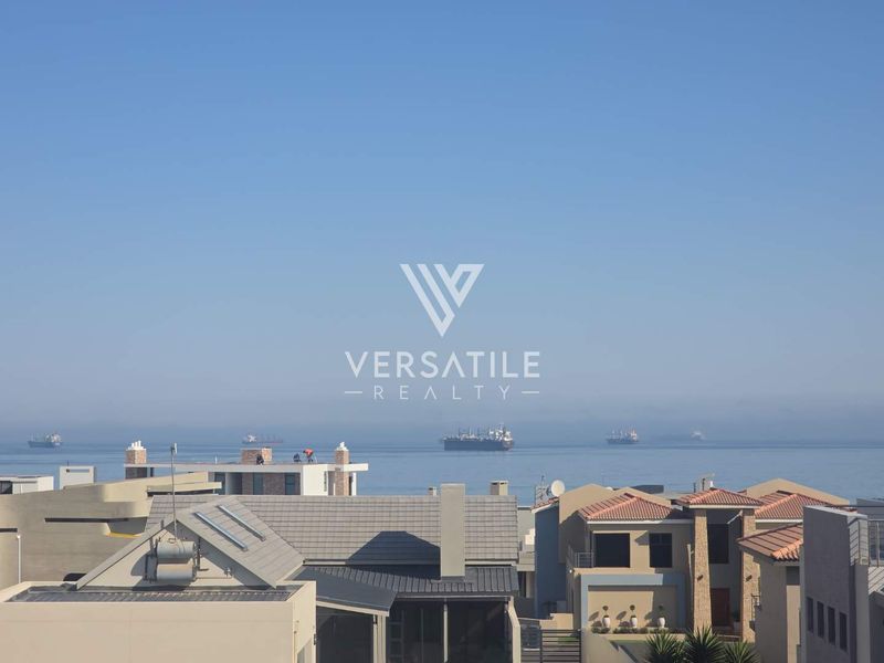 A scenic elevated view overlooking the ocean and surrounding residential rooftops.