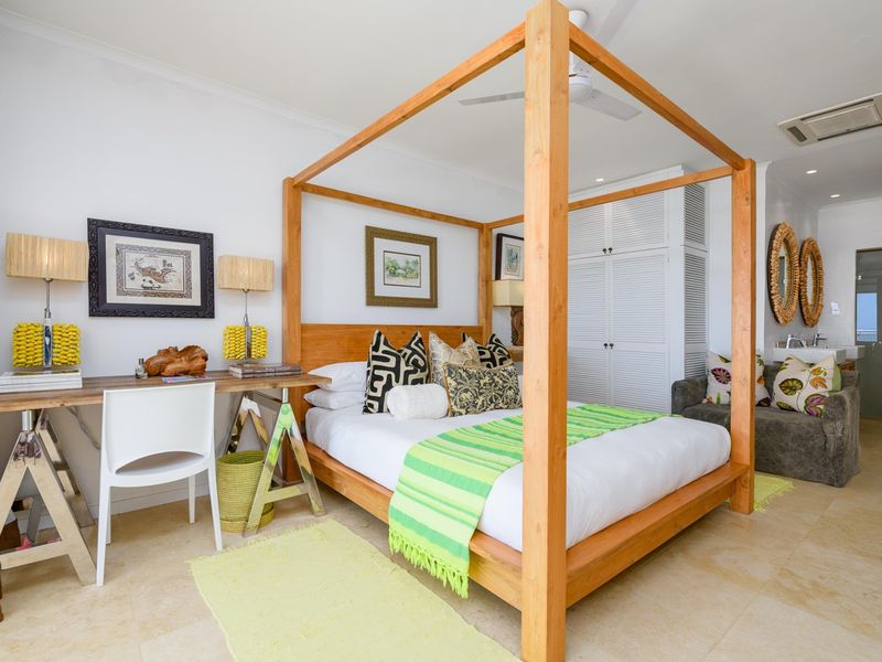 Spacious bedroom featuring tiled flooring, built-in wardrobe storage, ceiling fan, and integrated ducted air conditioning.