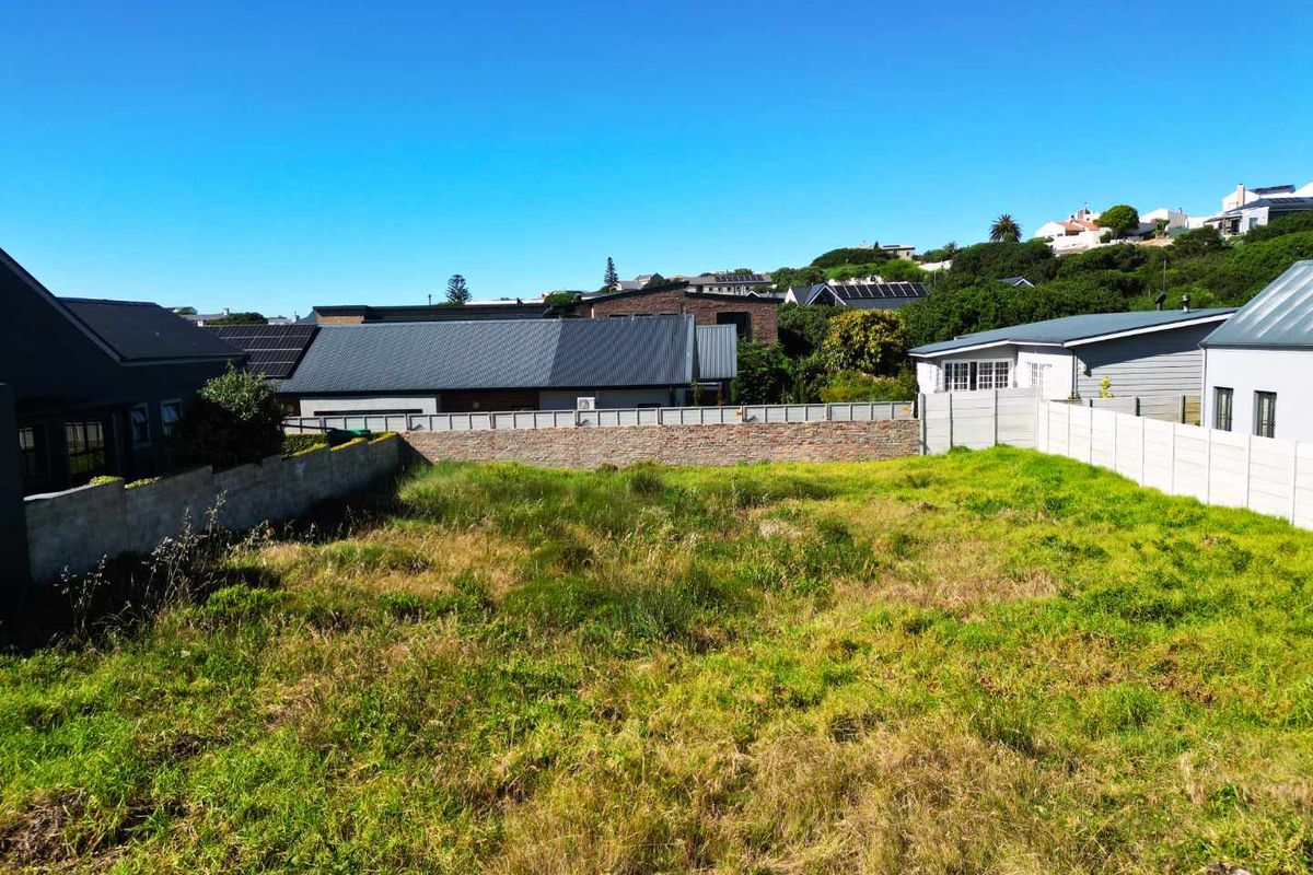 A vacant residential plot featuring established boundary walls and surrounding residential development in a quiet neighborhood setting.