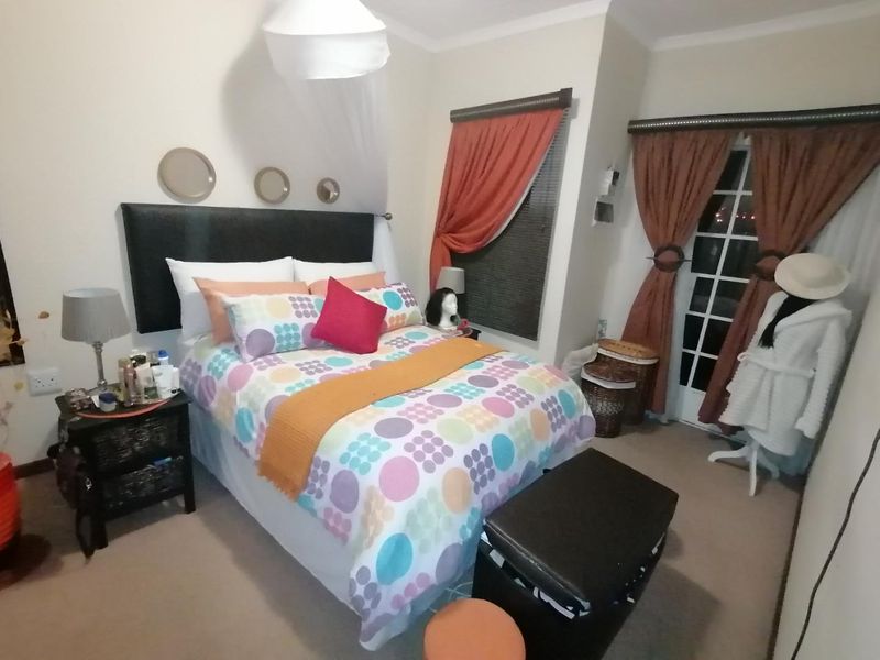 A cozy bedroom featuring carpeted flooring, a classic french door leading outside, and decorative coving detail.