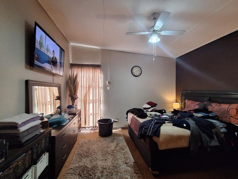A bedroom featuring a ceiling fan and a sliding glass door providing natural light.