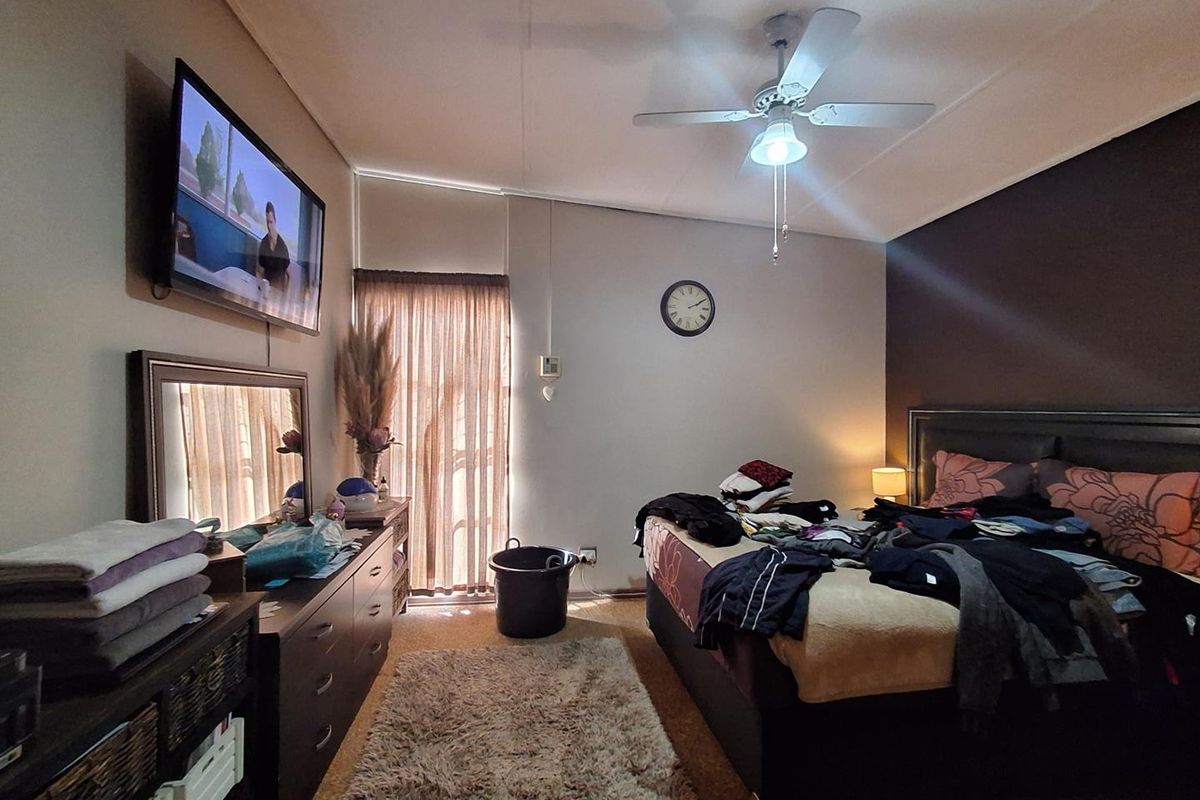 A bedroom featuring a ceiling fan and a sliding glass door providing natural light.
