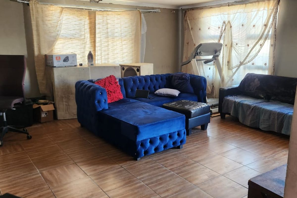 Living room featuring tiled flooring and a recessed ceiling design, currently requiring wall finishing and cosmetic updates to improve the overall aesthetic.