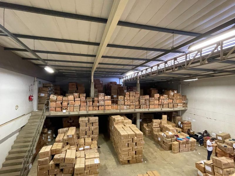 Large industrial warehouse space featuring a mezzanine level, exposed steel roof structure, and concrete flooring, suitable for storage or distribution operations.
