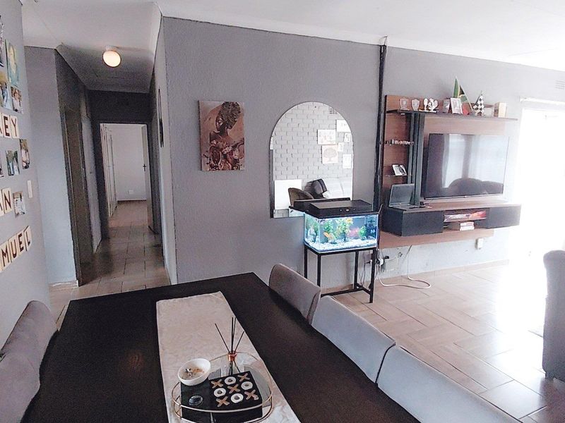 Open plan living and dining area featuring tiled flooring, a built-in media console, and neutral wall finishes.