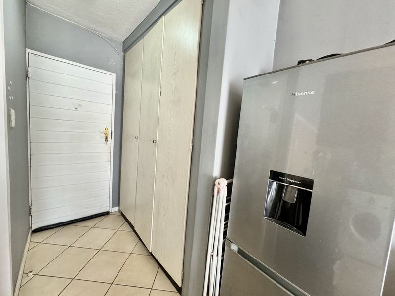 Entrance area featuring tiled flooring and built-in storage cupboards, providing functional storage space near the main apartment entry.