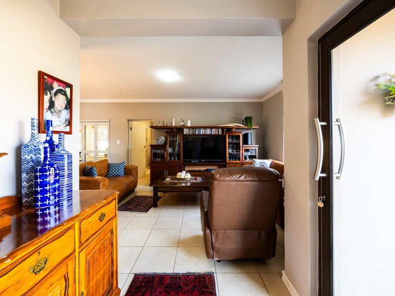 A view from the entrance into a living room featuring tiled flooring and a sliding glass door leading to the exterior.