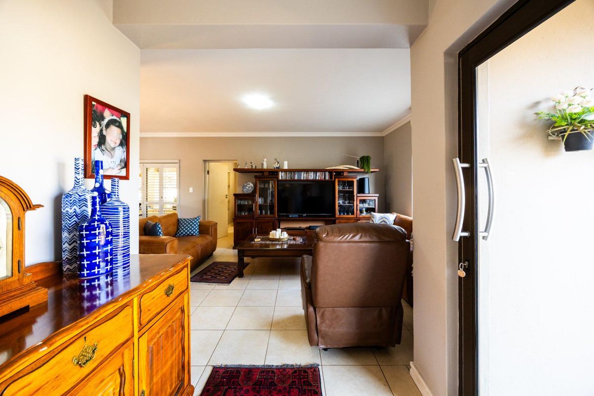A view from the entrance into a living room featuring tiled flooring and a sliding glass door leading to the exterior.