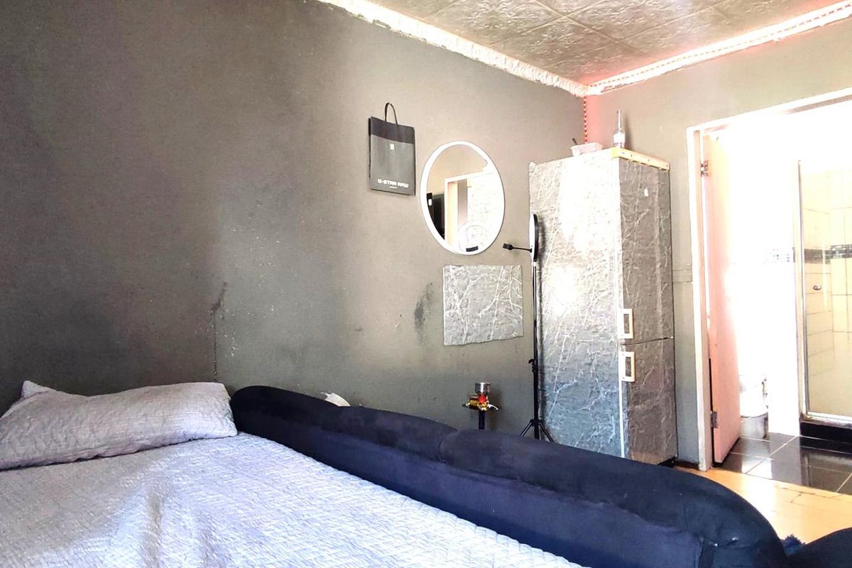 A bedroom featuring a textured ceiling and direct access to an adjoining bathroom.