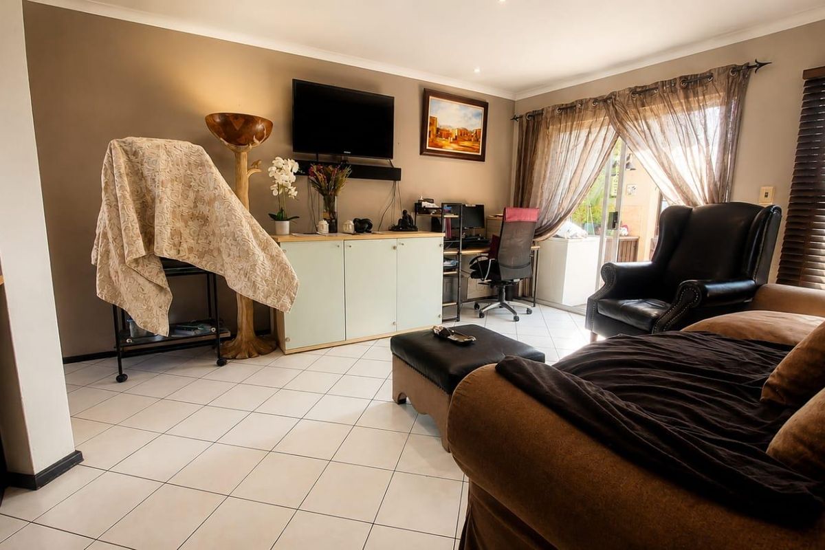A living room featuring tiled flooring, recessed lighting, and a sliding glass door providing access to an outdoor area.