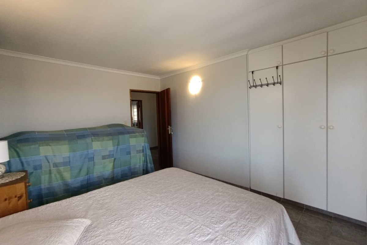 A bedroom featuring built-in cupboards and tiled flooring, providing functional storage space.
