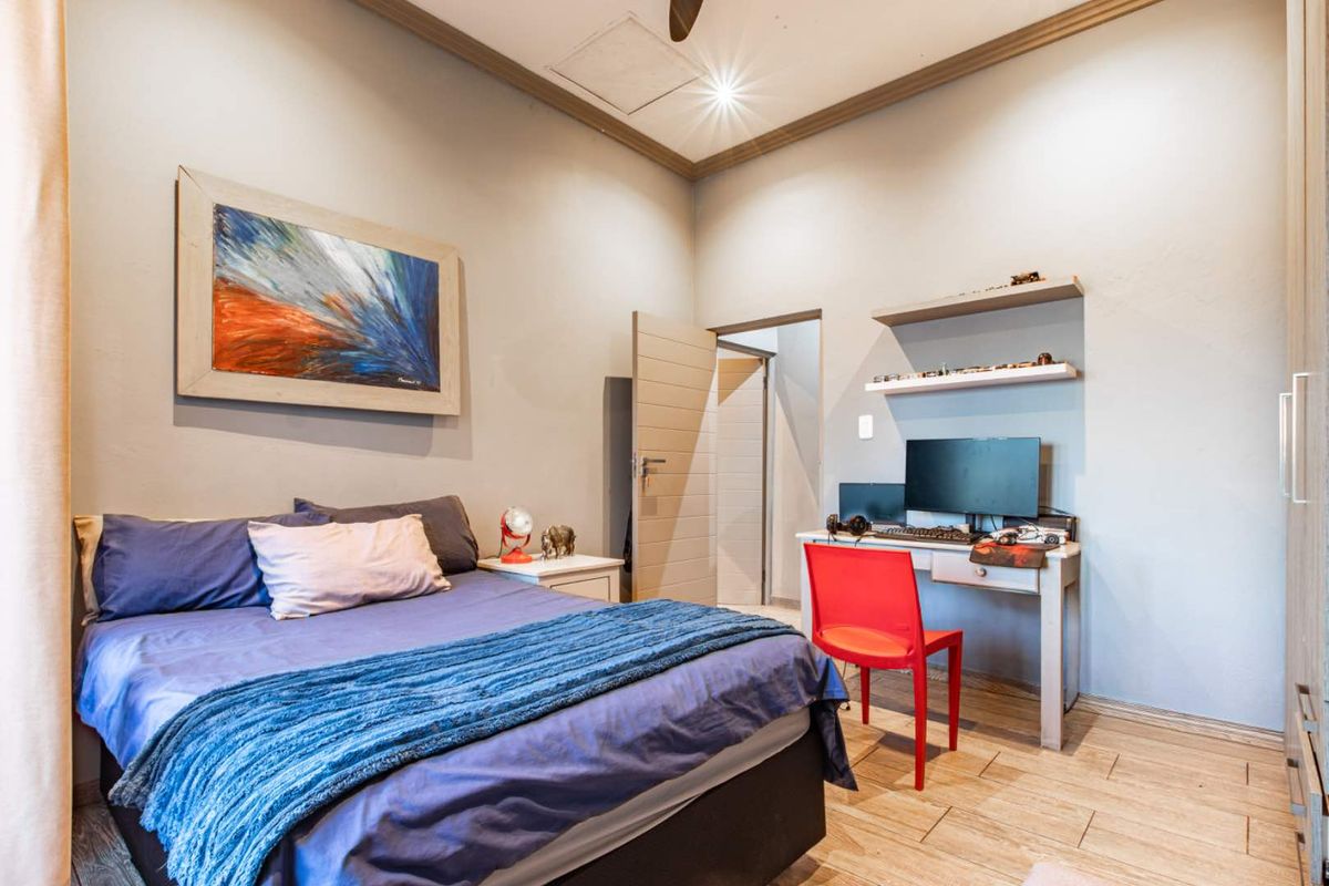 A well-maintained bedroom featuring tiled flooring, built-in shelving, and a neutral color palette, providing a functional and comfortable living space.