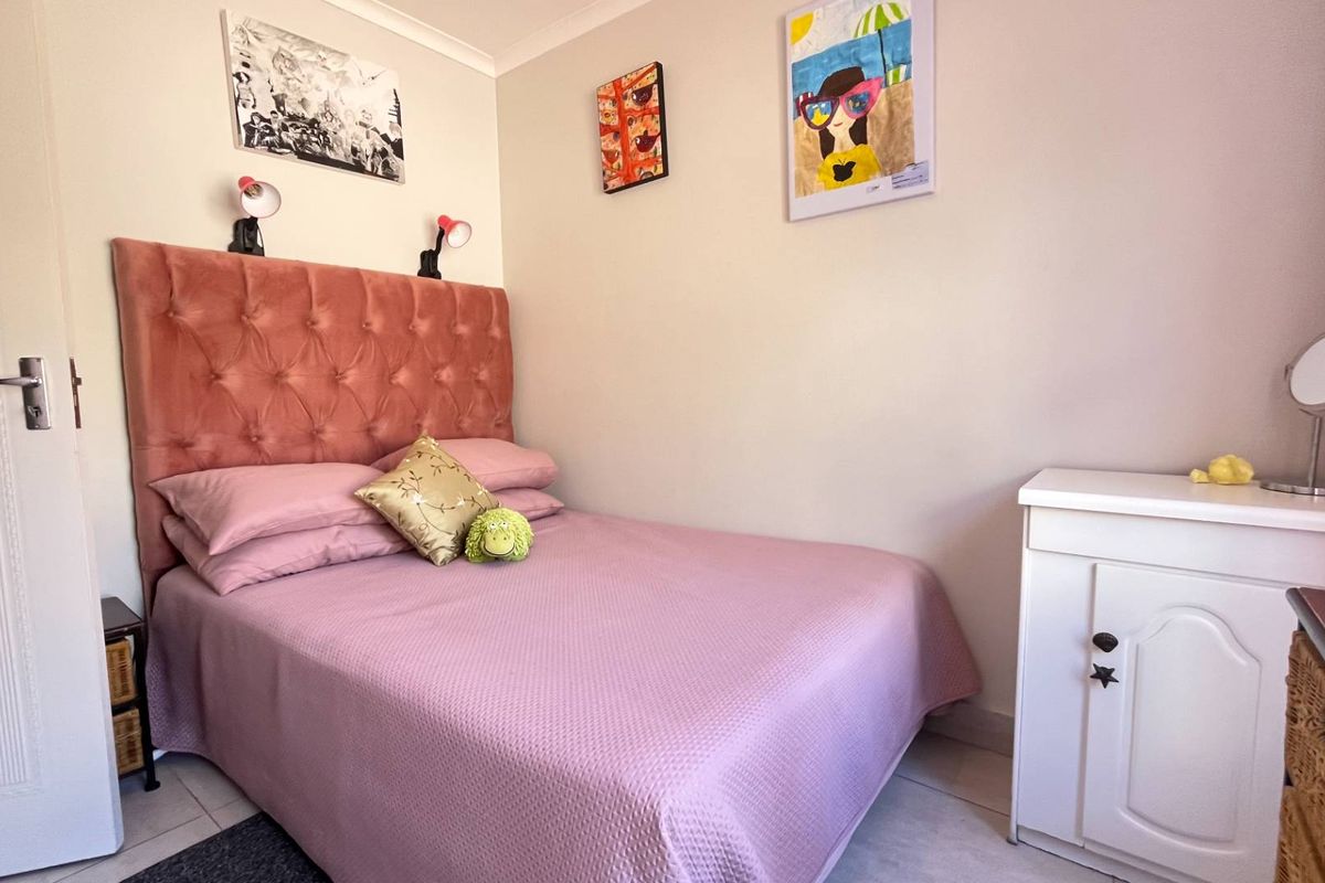 A compact bedroom featuring tiled flooring and a neutral color palette, providing a functional space for rest.