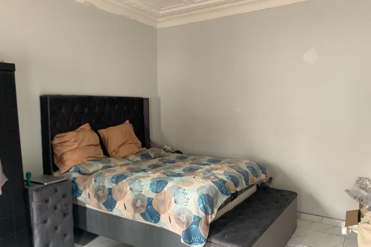 A bedroom featuring decorative coffered ceiling detailing and tiled flooring.