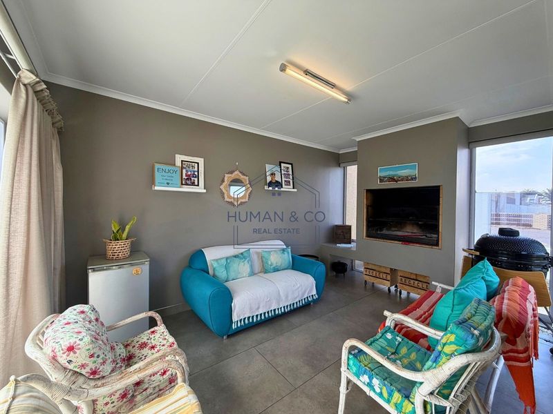 A living area featuring tiled flooring and a built-in braai, providing a functional space for indoor entertainment.