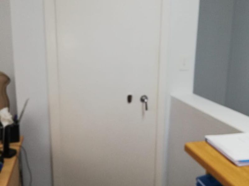 A view of a secure office door with heavy-duty hardware, situated within a professional workspace environment.