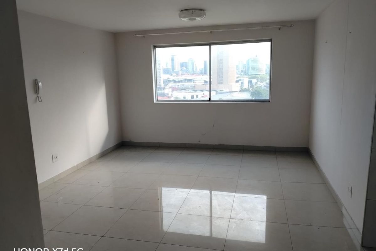 An empty bedroom featuring tiled flooring, a sliding window with city views, and an intercom system.