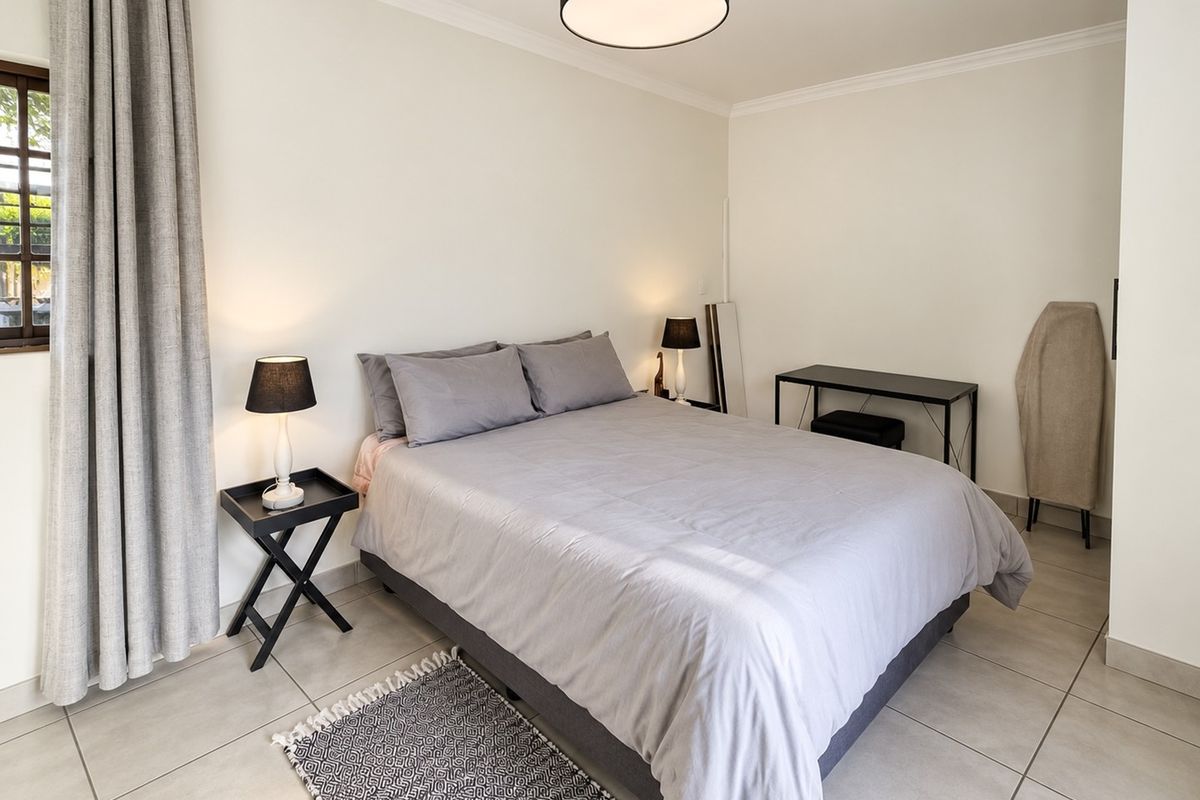 A well-maintained bedroom featuring neutral tiled flooring, crisp white walls, and classic cove cornicing, providing a clean and comfortable living space.
