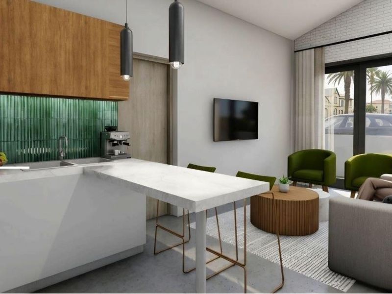 Modern open-plan living area featuring a sleek kitchen with stone countertops, green tile backsplash, and seamless access to the outdoor space.