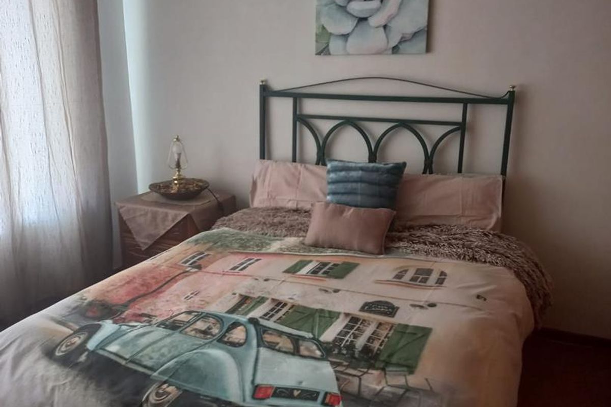 A standard bedroom featuring neutral walls and carpeted flooring, providing a functional and comfortable sleeping space.