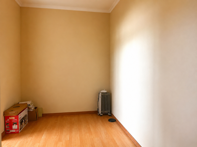 A vacant bedroom featuring light-toned laminate flooring, neutral walls, and classic coving, offering a blank canvas for personalization.