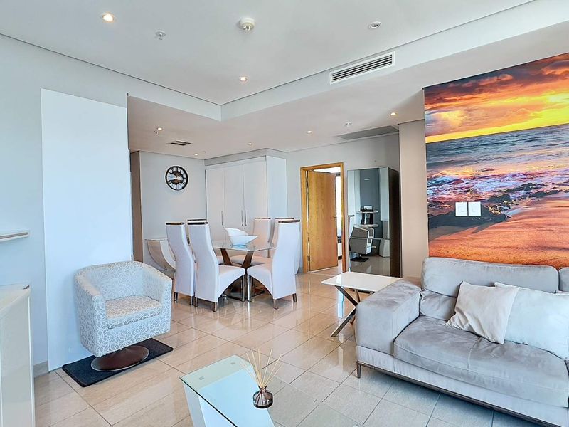 Spacious open-plan living and dining area featuring neutral porcelain floor tiles, recessed lighting, and integrated ducted air conditioning.