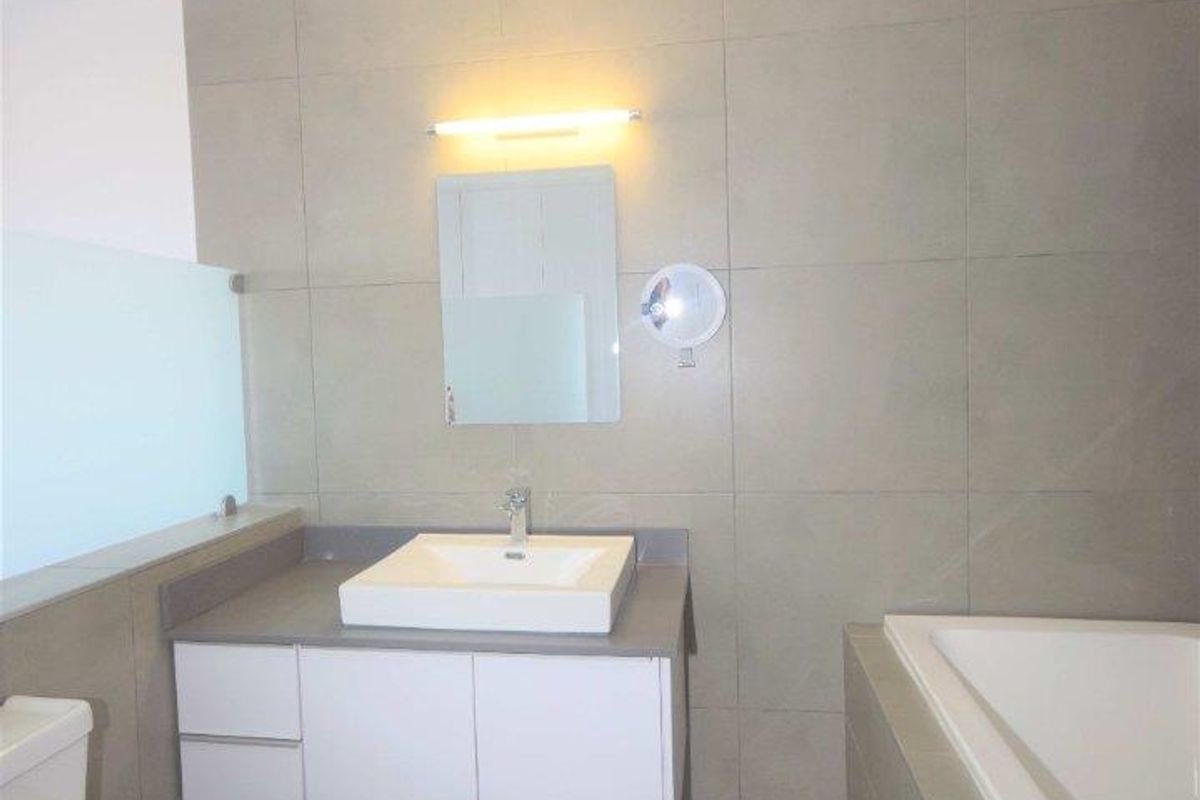 Modern bathroom featuring a floating vanity with a vessel sink, a built-in bathtub, and large-format neutral wall and floor tiles.