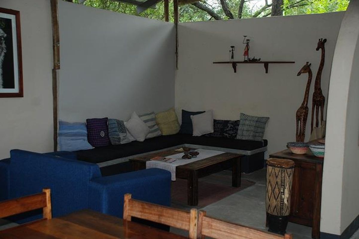 A cozy, semi-open living area featuring built-in bench seating and a concrete floor, set within a lodge-style environment.