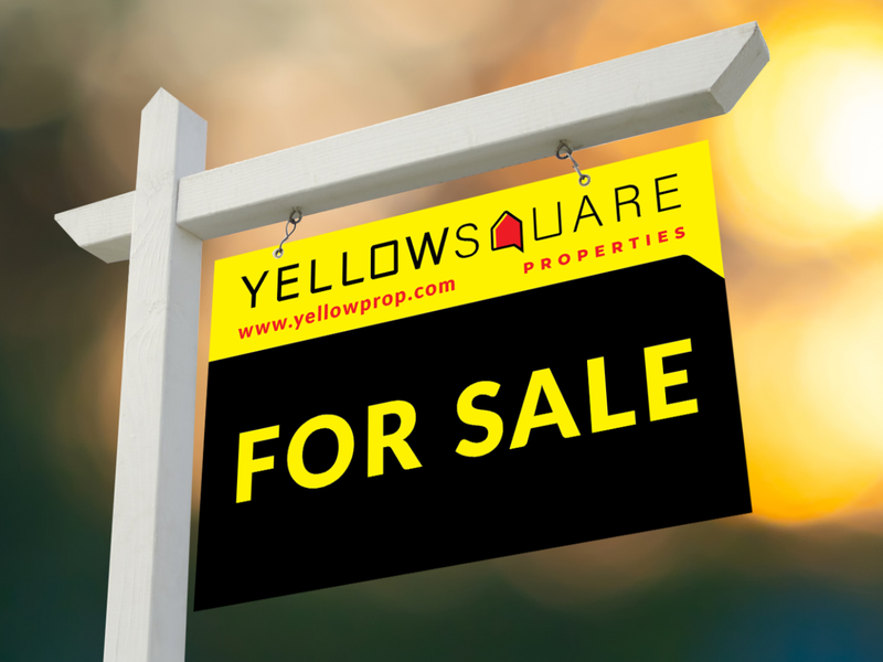 A real estate for sale sign displayed on a post.