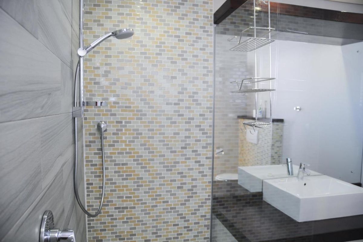 Modern bathroom featuring a glass-enclosed shower with mosaic tile accent wall and a contemporary vessel sink vanity.