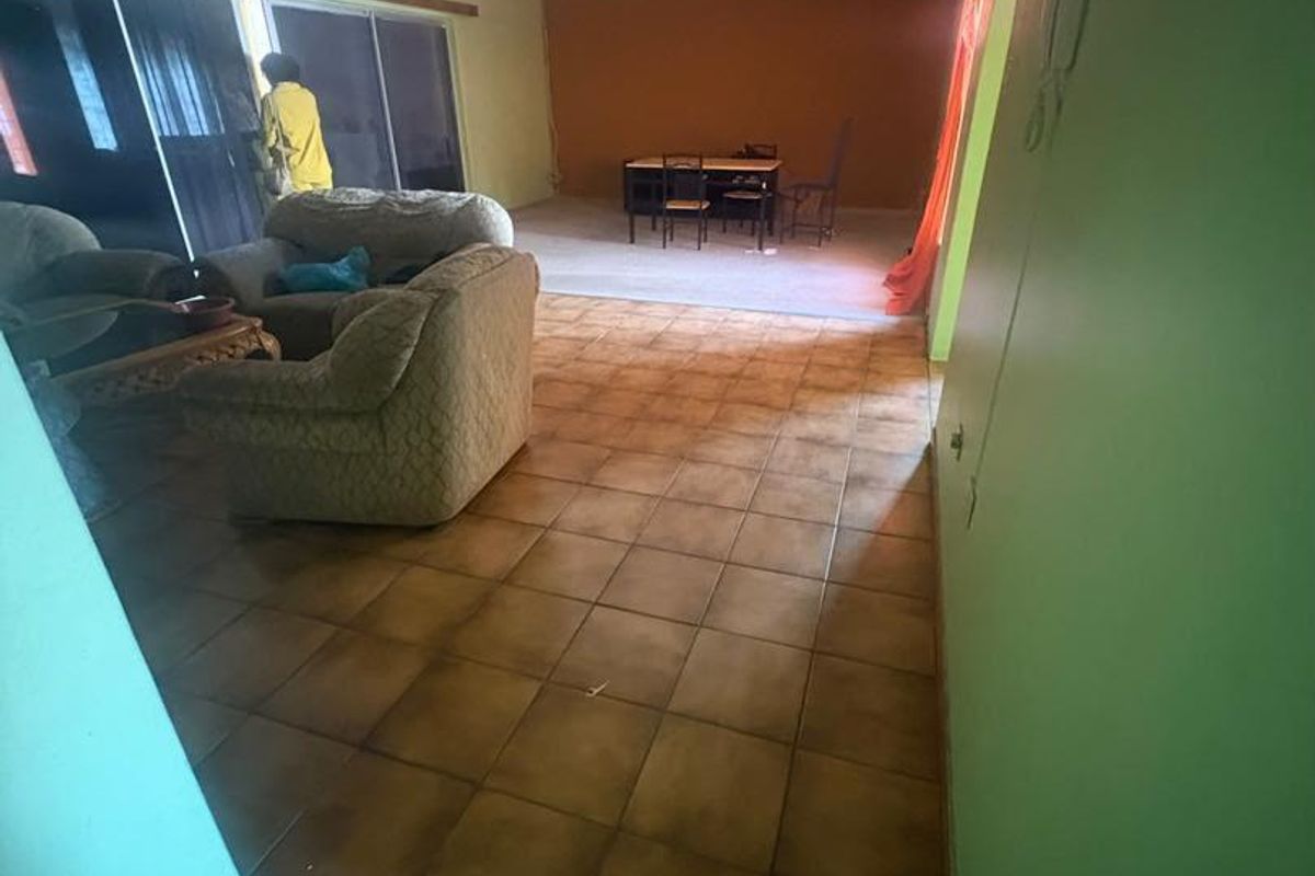 Open plan living and dining area featuring ceramic tiled flooring and large sliding glass doors providing access to the exterior.