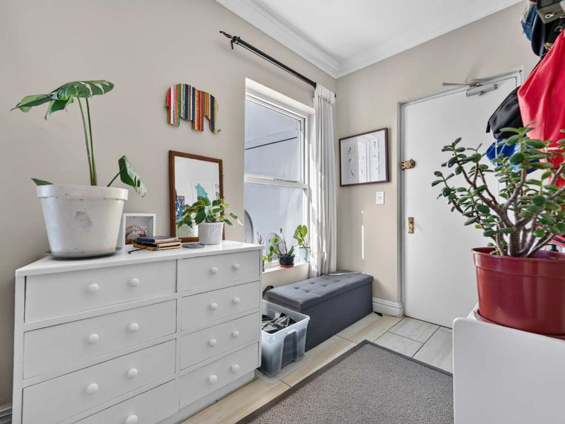 A bright and welcoming entrance area featuring tiled flooring, neutral wall tones, and a window that allows for natural light.