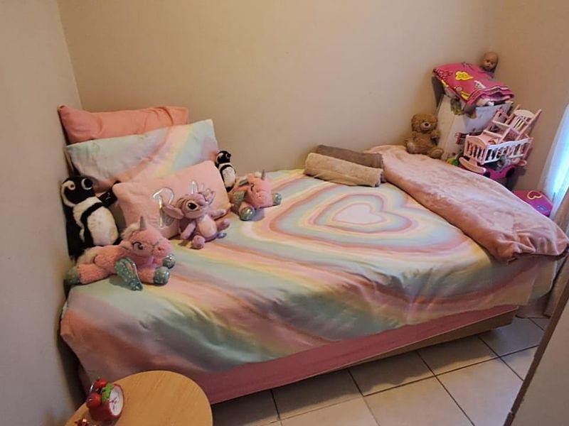 A compact bedroom featuring tiled flooring and a window, providing a functional space for a single bed.