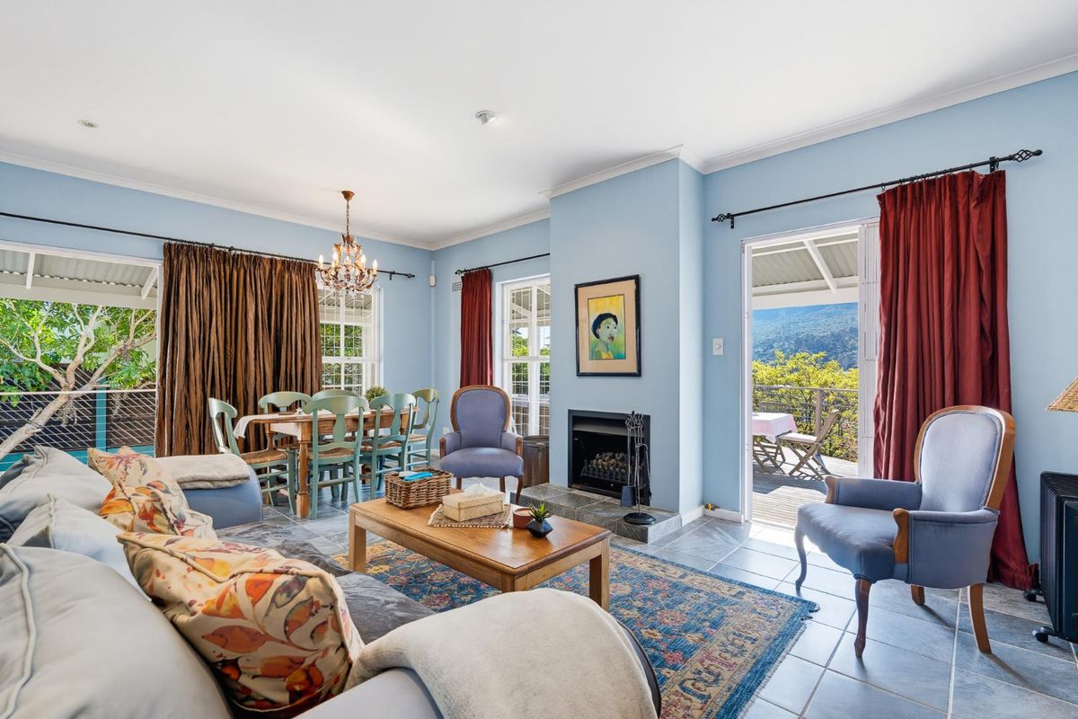 Spacious living room featuring a fireplace with stone hearth, tiled flooring, and direct access to an outdoor patio area with scenic views.