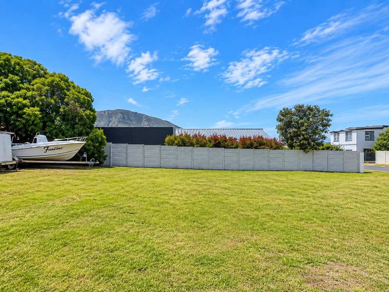 A spacious, level residential plot featuring a well-maintained lawn and a secure precast concrete boundary wall.