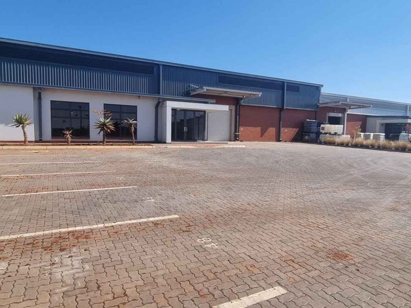 A well-maintained industrial property featuring a paved parking area, modern metal and brick facade, and clear commercial access points.