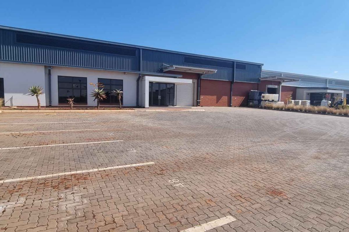 A well-maintained industrial property featuring a paved parking area, modern metal and brick facade, and clear commercial access points.