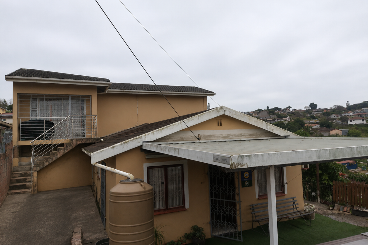 Rear view of the property featuring a covered patio area, external staircase leading to an upper level, and a water tank installation.