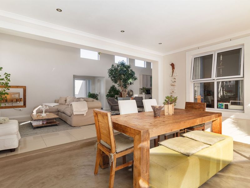 Spacious open-plan living and dining area featuring a split-level floor design, recessed lighting, and large windows allowing for ample natural light.