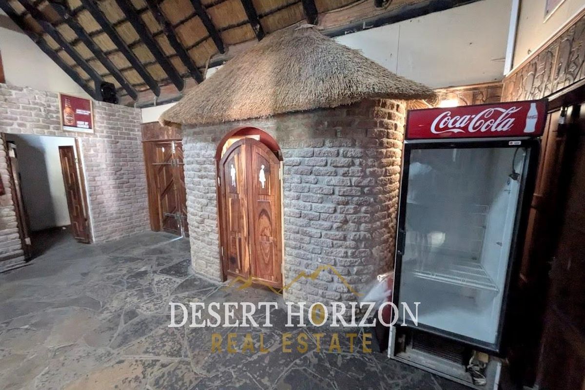 Interior view of a rustic-style facility featuring a unique thatched-roof structure, exposed brick walls, and natural stone flooring.