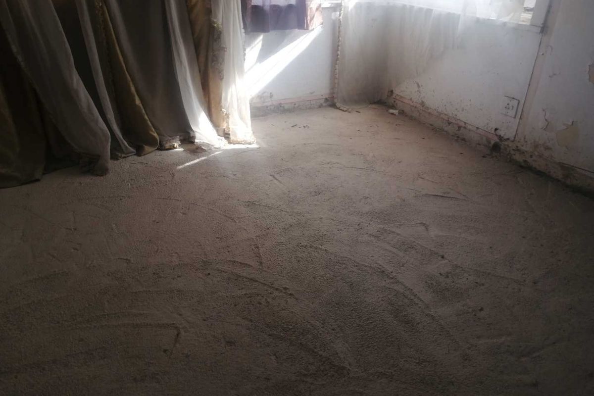 A bedroom interior showing significant wear to the wall finishes and flooring, requiring renovation and cosmetic updates.