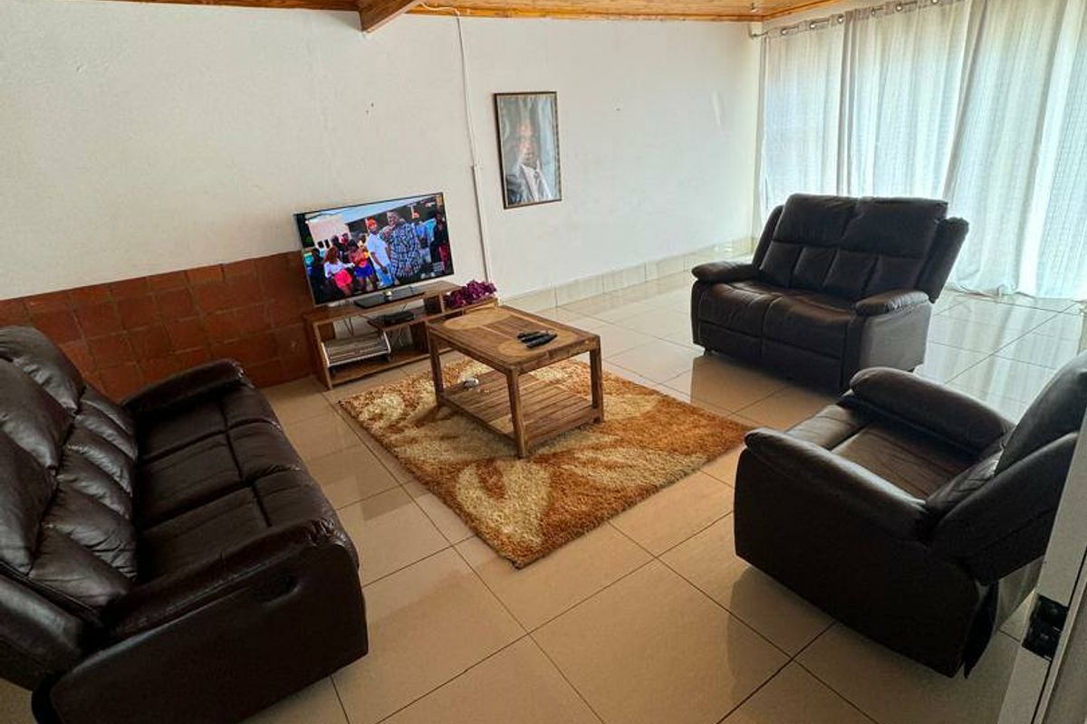 Spacious living room featuring large format floor tiles and a distinctive timber-clad vaulted ceiling, providing a warm and traditional aesthetic.