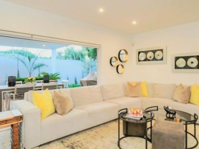 Spacious open-plan living area featuring recessed downlighting and large sliding glass doors that provide seamless access to the covered outdoor patio.